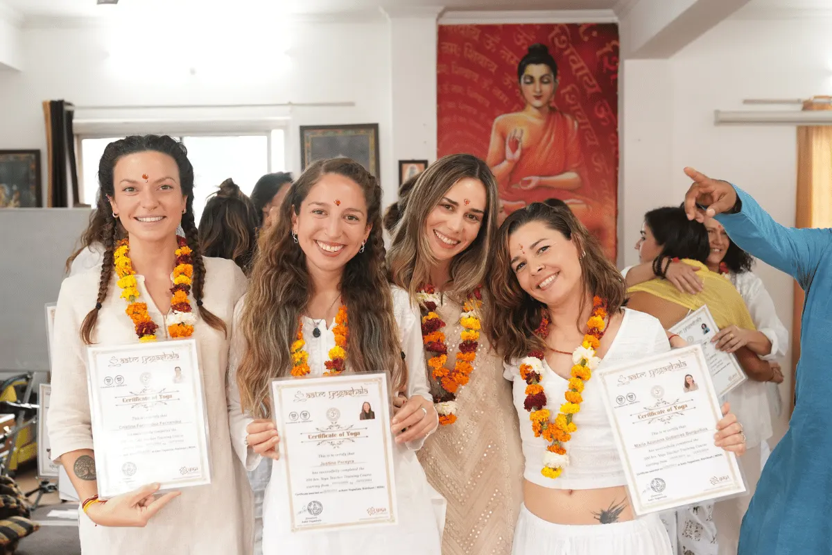 Proud yoga graduates holding Yoga Alliance certified certificates at 200 Hour Yoga TTC graduation ceremony