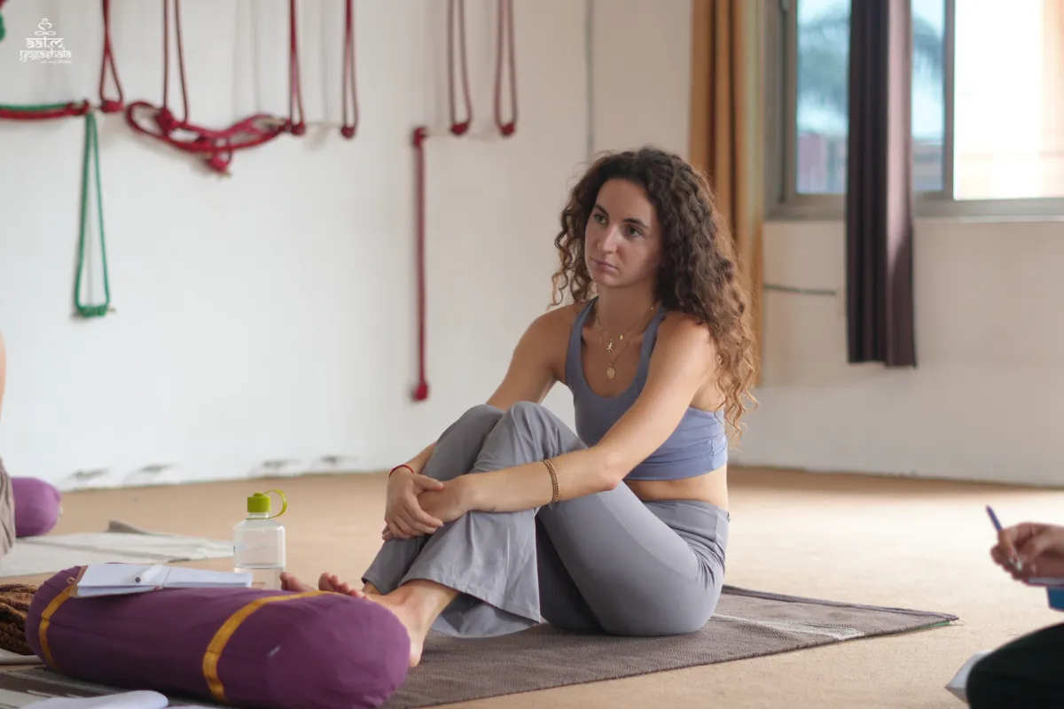 Yoga student studying Patanjali yoga philosophy and anatomy in 300 Hour Yoga Teacher Training hall at Aatm Yogashala Rishikesh