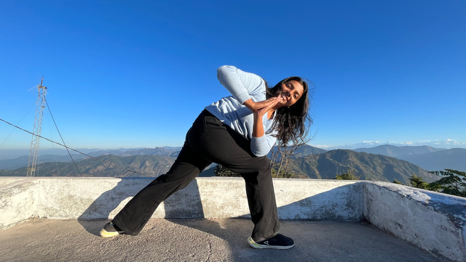 Woman practicing yoga during Himalayan yoga and meditation retreat in Rishikesh with mountain view