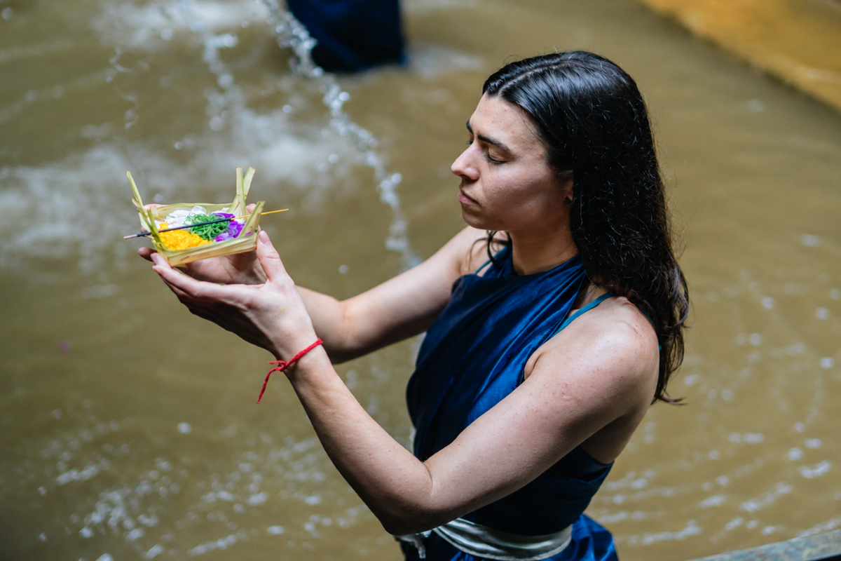 International yoga student performing a water purification ritual in Bali