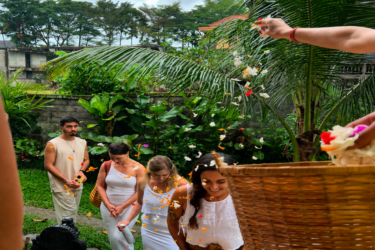 Students taking part in a flower petal blessing ceremony during the 100 Hour Yoga Teacher Training in Bali