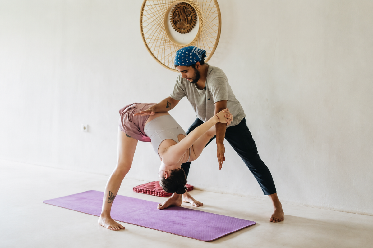 Teacher assisting student with Hatha Yoga alignment during the 100 Hour Yoga Teacher Training in Bali