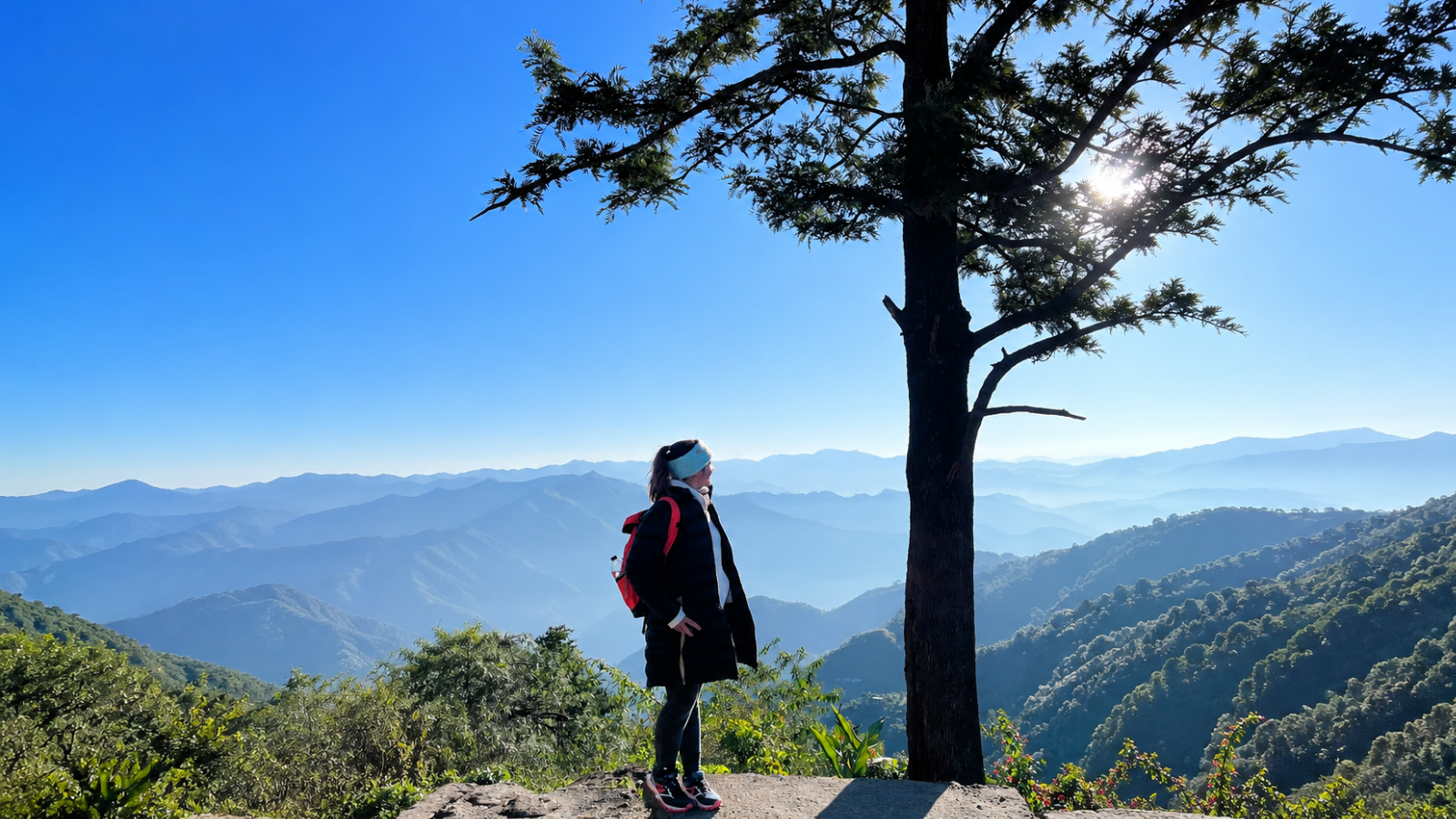 Woman enjoying peaceful Himalayan mountain view during yoga retreat in Rishikesh India