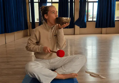 Student practicing Tibetan singing bowl sound healing meditation in Rishikesh